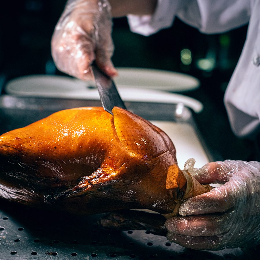 A chef carving out pieces of Peking duck at Duck De Chine by 1949