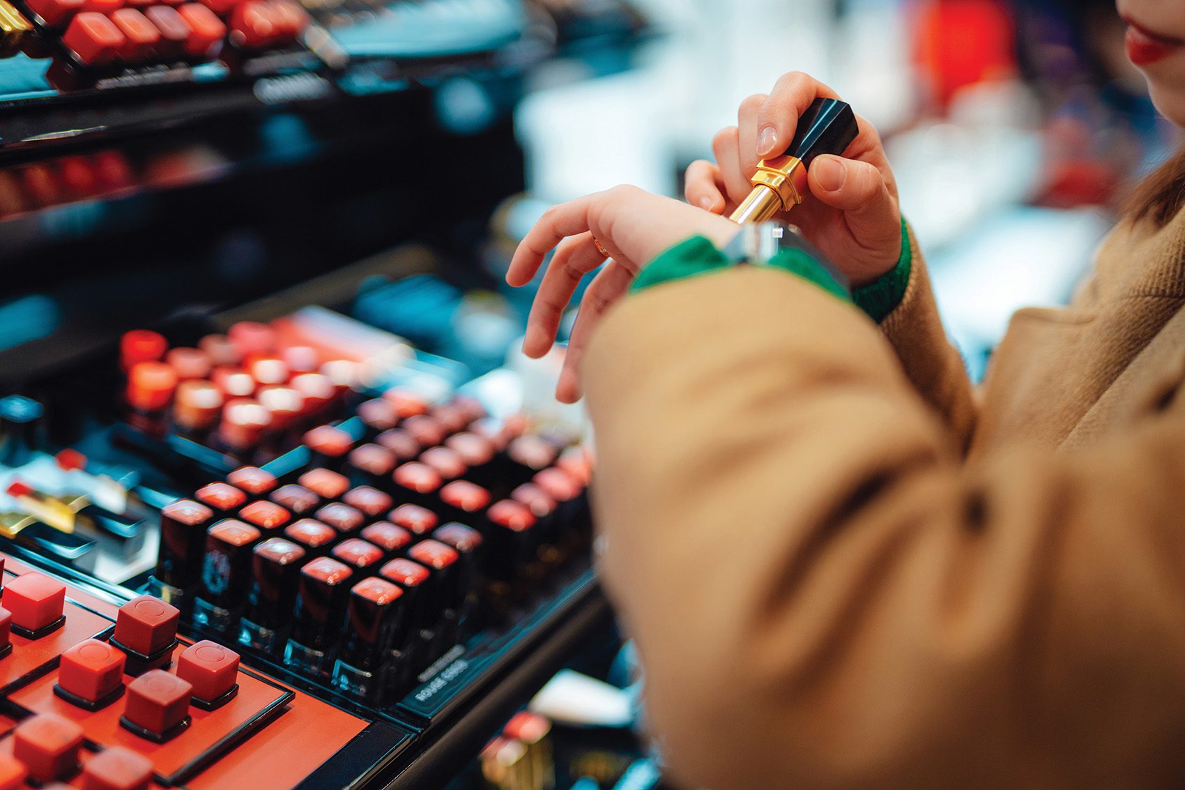 A customer testing lipstick colours at a cosmetics store