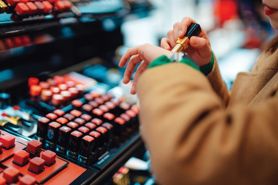 A customer testing lipstick colours at a cosmetics store