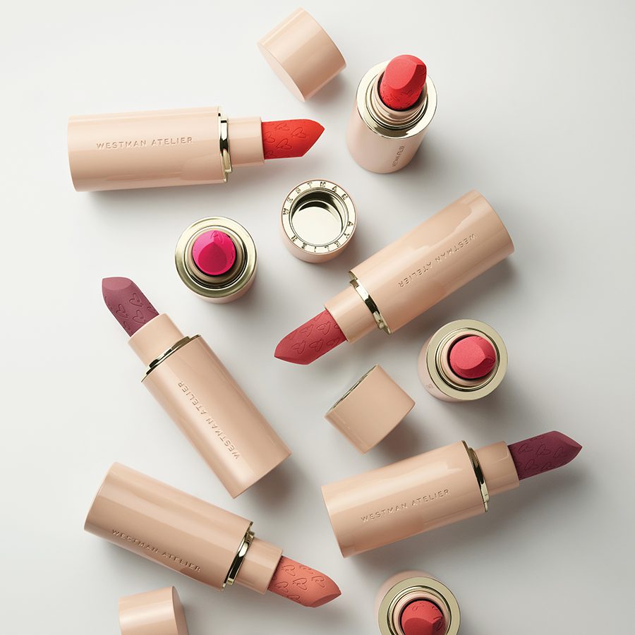  A selection of Westman Atelier lipsticks with their lids off on a white surface