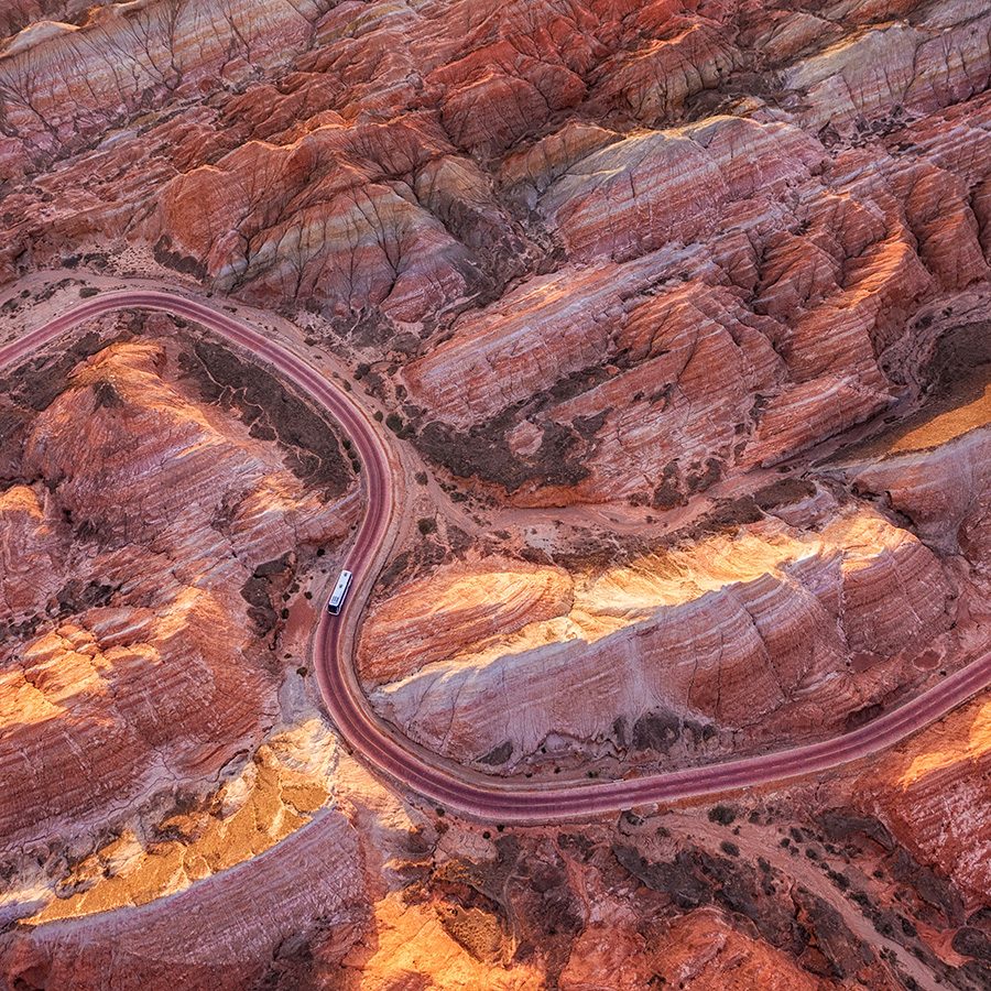 Aerial view of a road winding through the colourful rock formations of Zhangye National Geopark