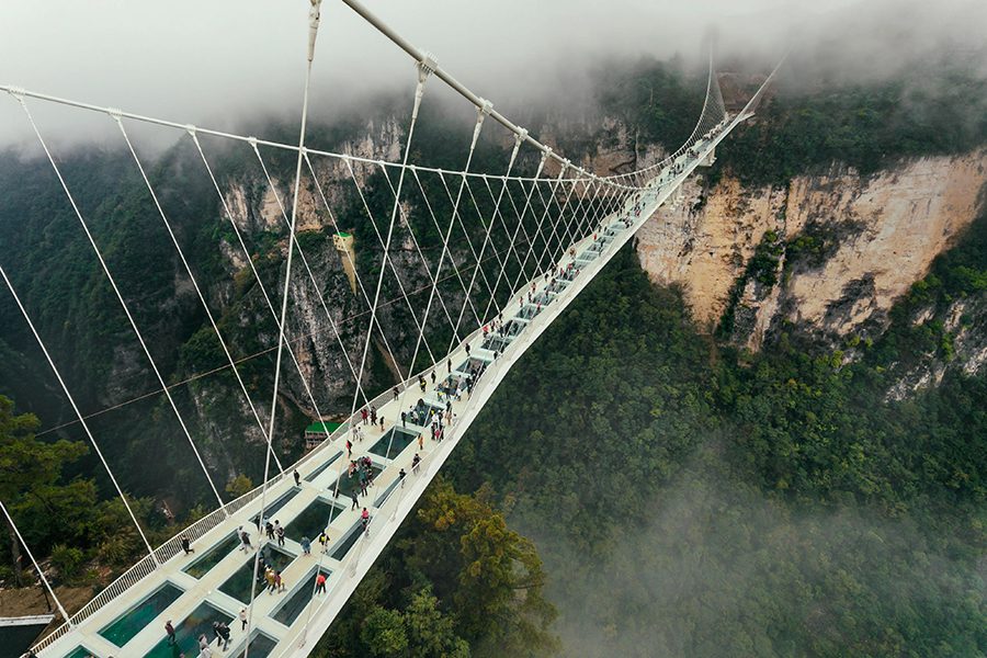 A glass bridge with people walking on it in Zhangjiajie