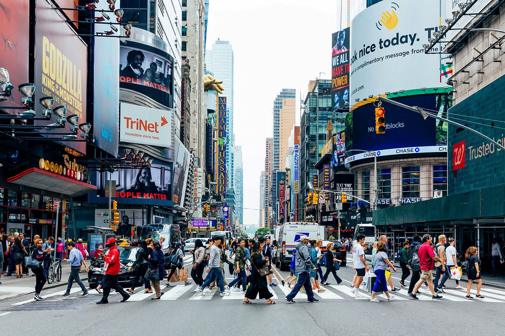 A large number of pedestrians crossing the street in New York City.