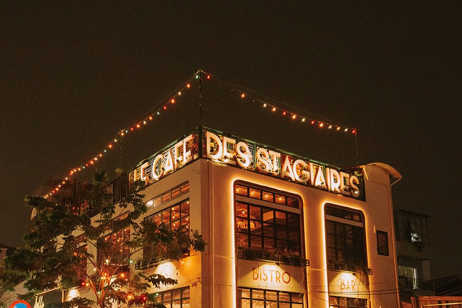 External view of rooftop bar Le Cafe de Stagiaires at night.