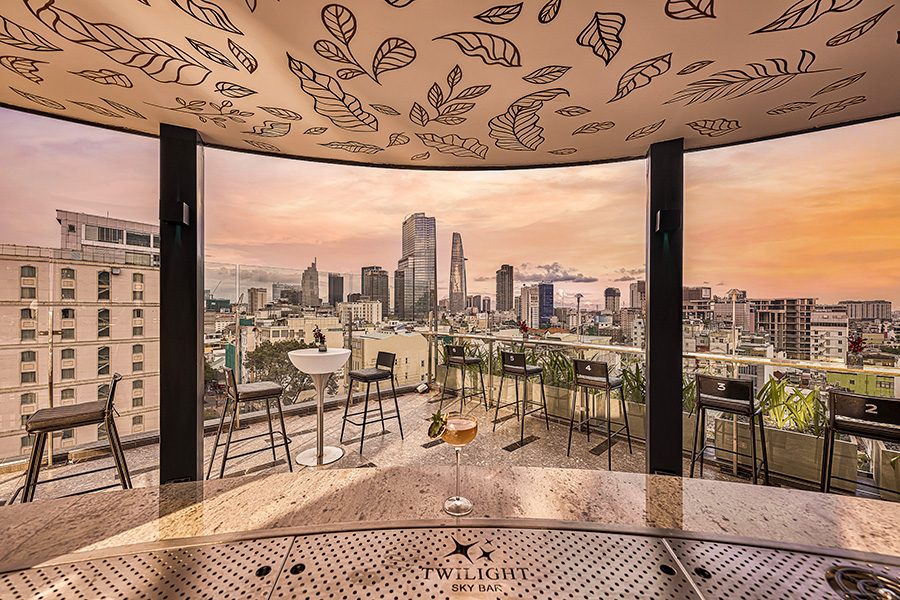 Interior view of Twilight Sky Bar from inside the bar with a panoramic view of Ho Chi Minh City at dusk from the rooftop. 
