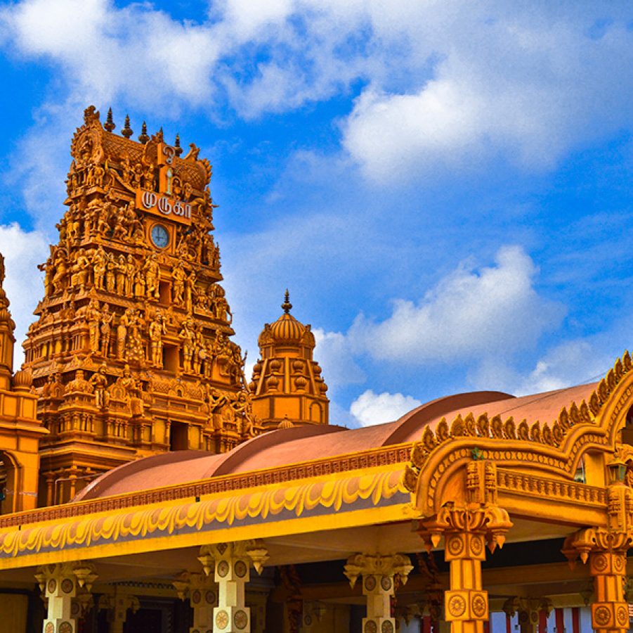 A temple’s gilded entrance tower with a clock. 