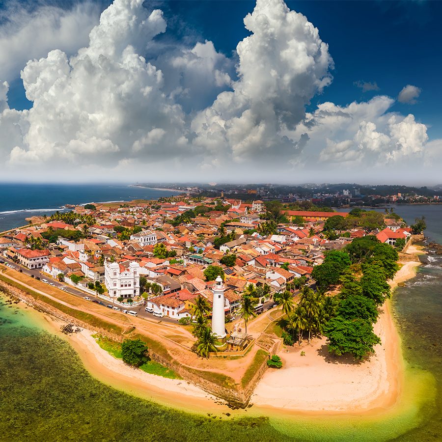 Aerial view of an island with a lighthouse.