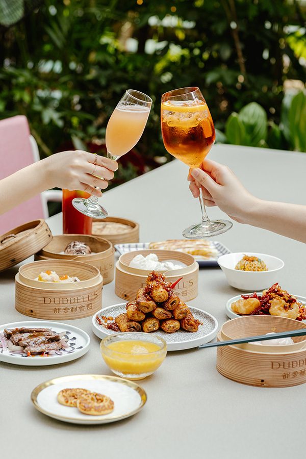 People clinking glasses over dishes from Duddell’s in Hong Kong