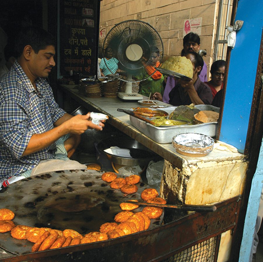 An Indian man working at a food stall in Delhi.