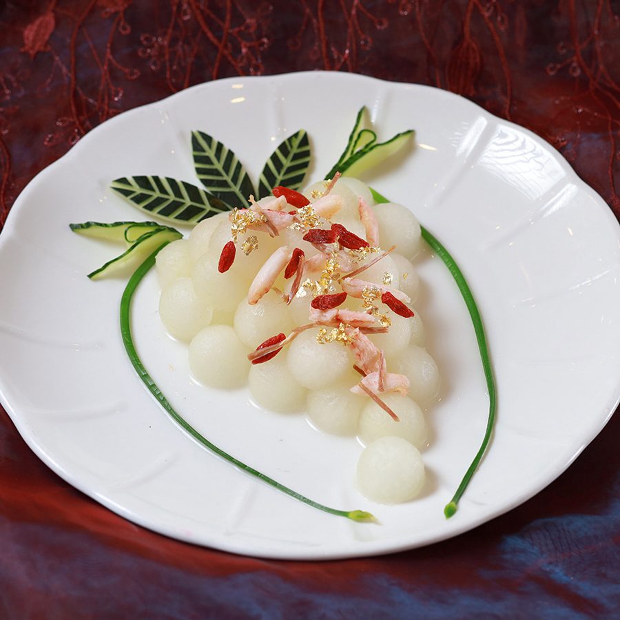 A plate of steamed winter melon balls and Yangcheng Lake hairy crab slices, goji berries and gold leaves