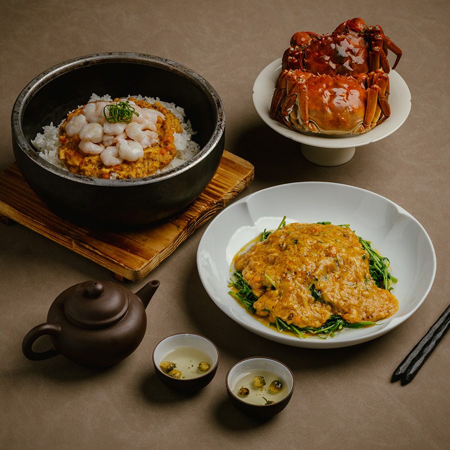 A set meal of crab meat and river shrimp on steamed rice in a stone pot, a plate of braised bean sprouts and crab meat sauce and a plate of hair crab in the background, served at Chinese restaurant Moments Together in Hong Kong 