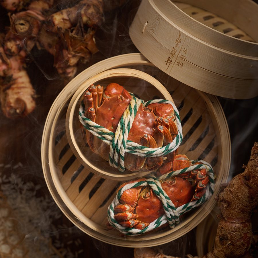 A bamboo steamer basket with two pieces of hairy crab and dried galangal in the background, featured on the set menu at Tse Yuet Heen in Tsuen Kwan O, Hong Kong 