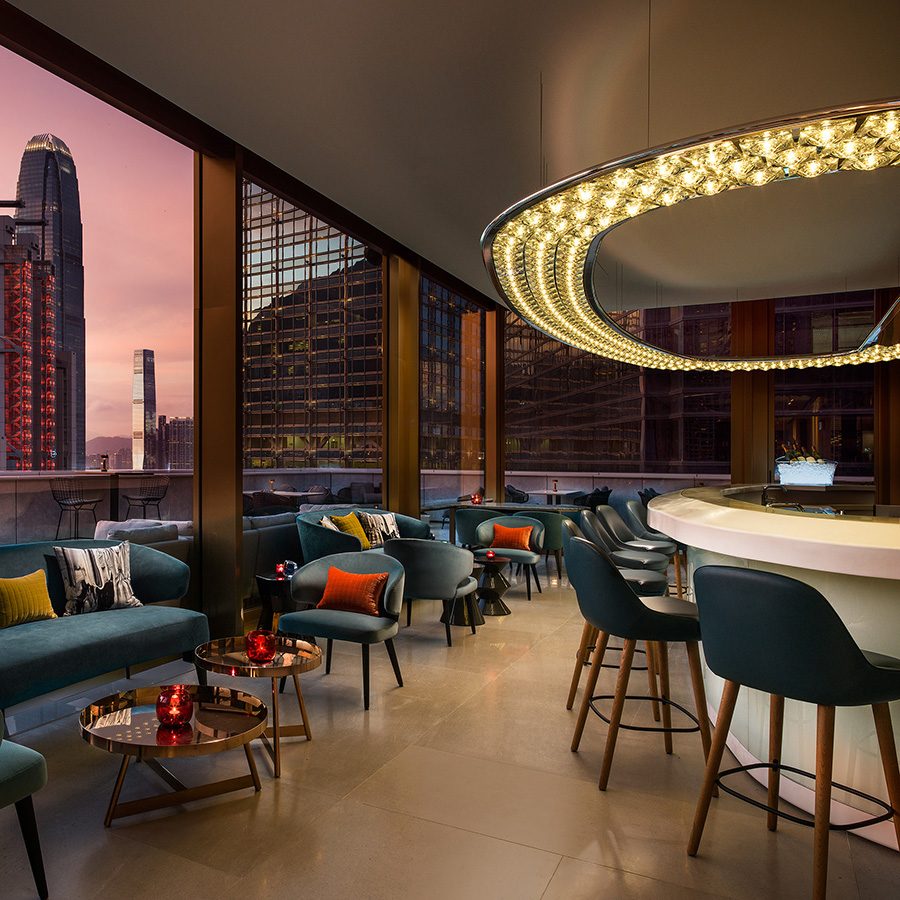 The interior of Popinjays at The Murray in Hong Kong. Skyscrapers including the HSBC Main Building, ifc and ICC are visible through the windows. 