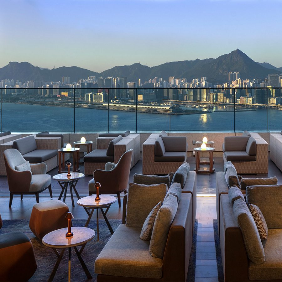 The outdoor terrace of Sugar at East Hotel in Hong Kong. The hills and buildings across the harbour are in the background. 