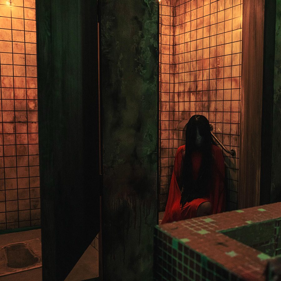 Woman sits in a dirty bathroom at Airside’s Hollow City.
