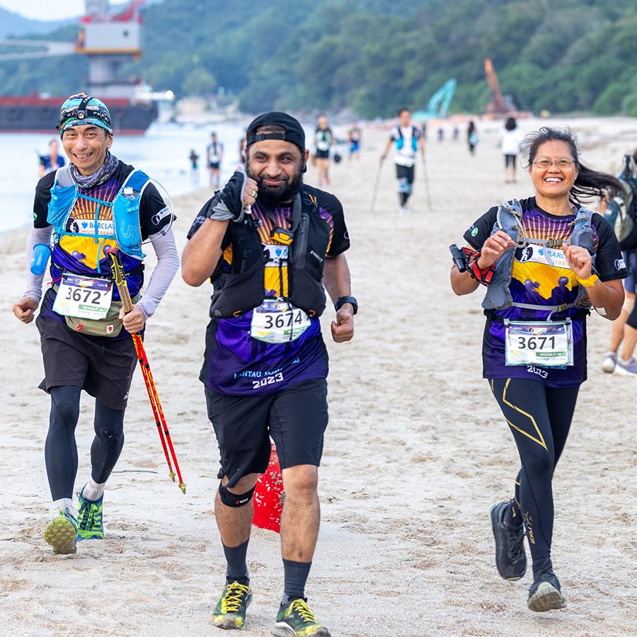 Runners racing along a beach during Moontrekker Hong Kong.