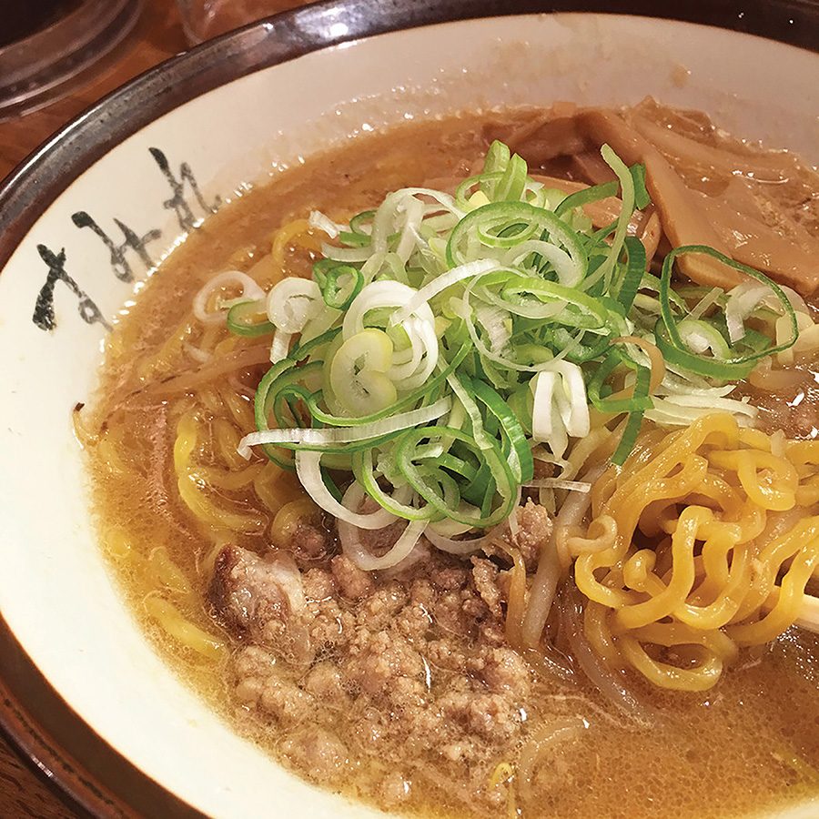 A close-up of a bowl of ramen in shoyu broth with scallion spring onions garnished on top served at Maruha Beyond in Sapporo, Hokkaido, Japan