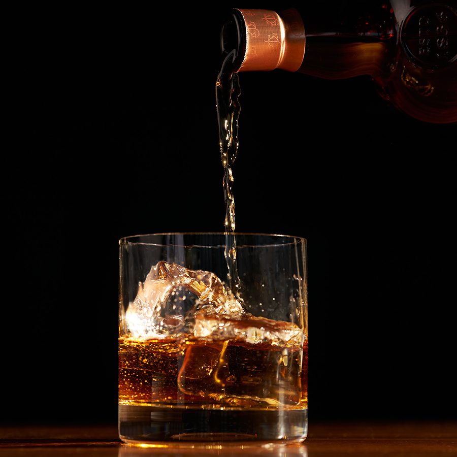 Glenfarclas for Cathay whisky being poured into a glass containing ice cubes.  
