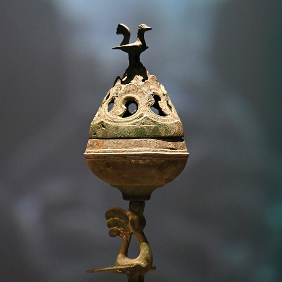 Close-up of a Chinese artefact with a bird on top. 