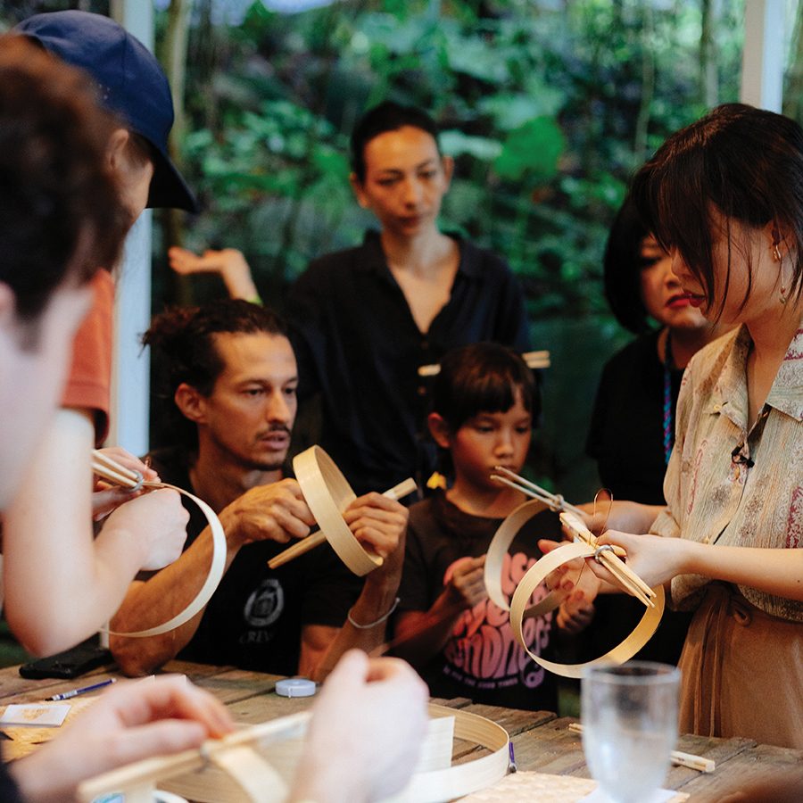A group of people sitting around a table working on a craft project.