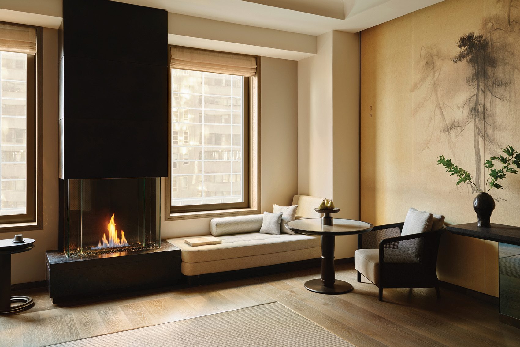 A cream-coloured room with a fireplace and couch, at Aman New York hotel 