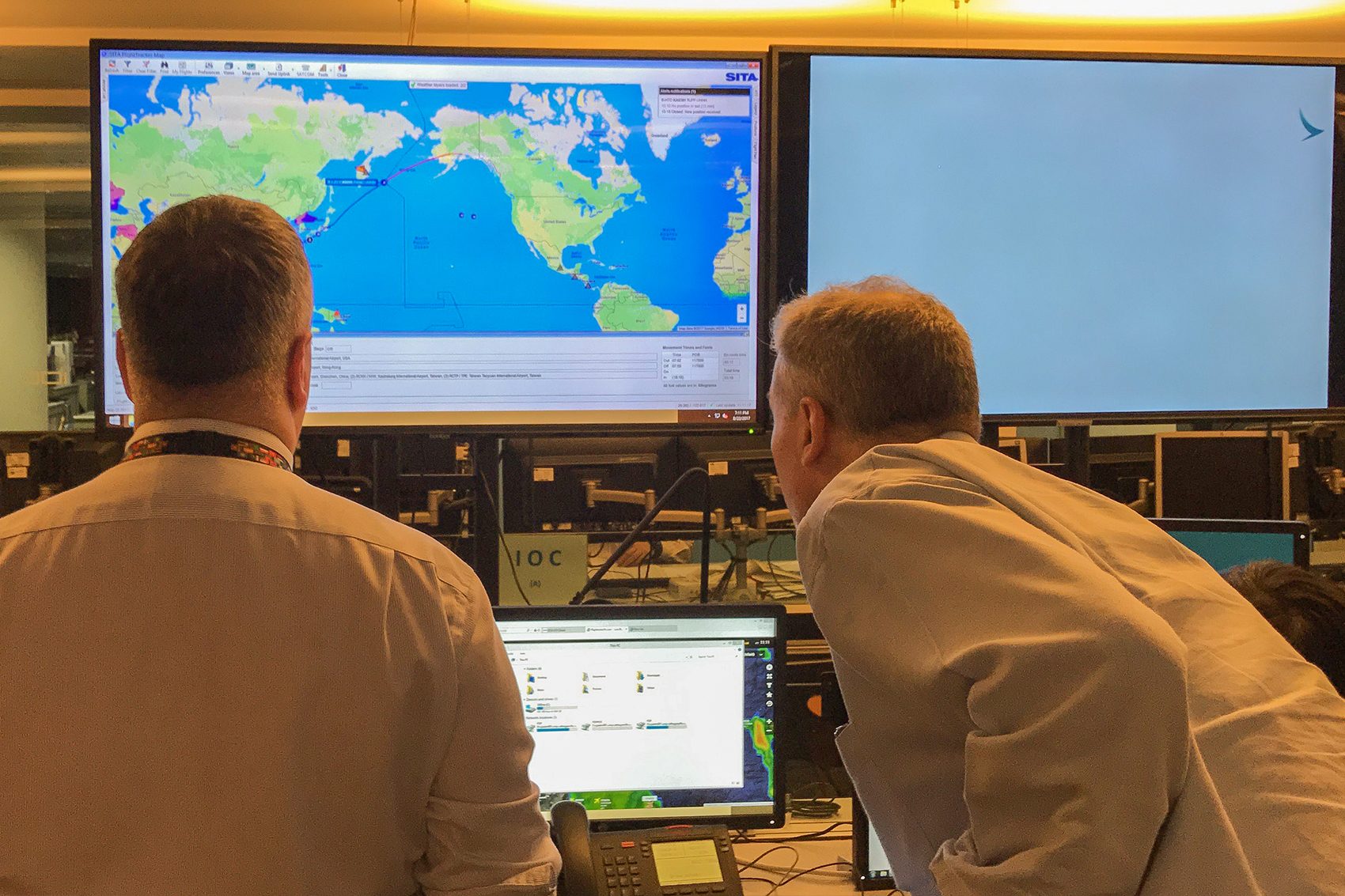Two men watching the weather on computer screens at the Integrated Operations Centre (IOC) at Cathay Pacific’s headquarters