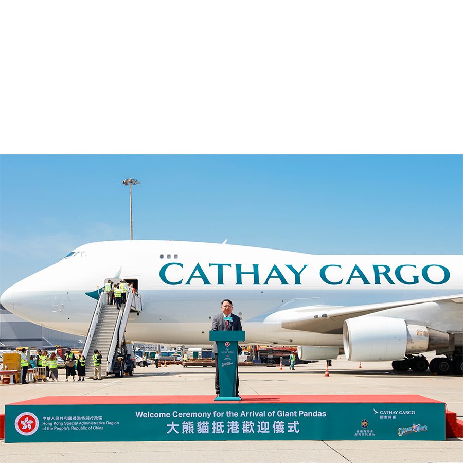 Chief Secretary of Administration of Hong Kong Eric Chan gives a speech in front of a parked Cathay Cargo plane