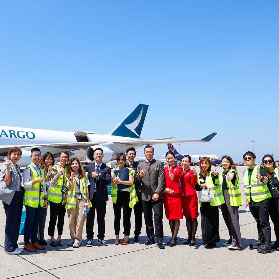 Group photo of Cathay staff on the tarmac in front of a Cathay Cargo plane  