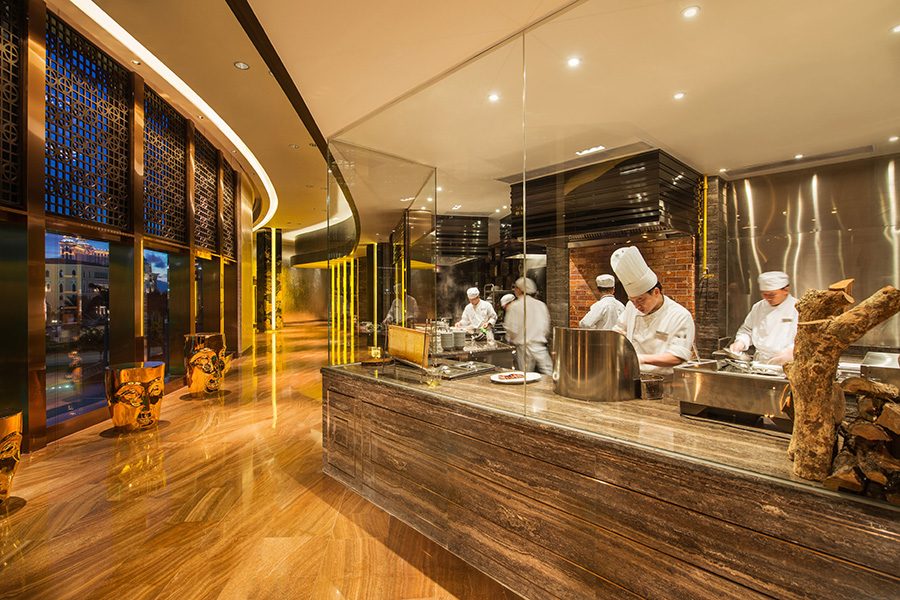 A row of chefs working behind a glass wall at Jade Dragon.  