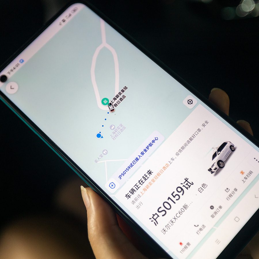Close-up of a hand holding a smartphone with a ride-hailing app open.  