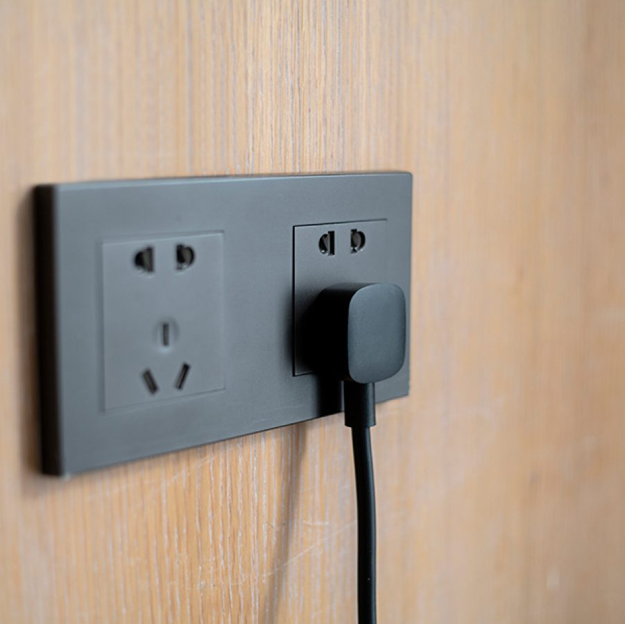 A black plug in a wall socket. 