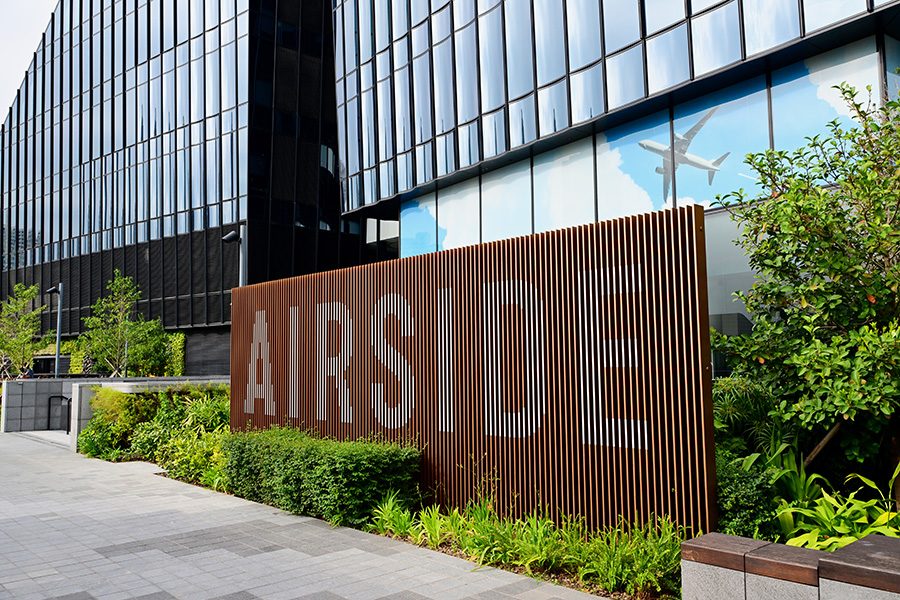 Close-up of the sign in front of Airside and the greenery around it.
