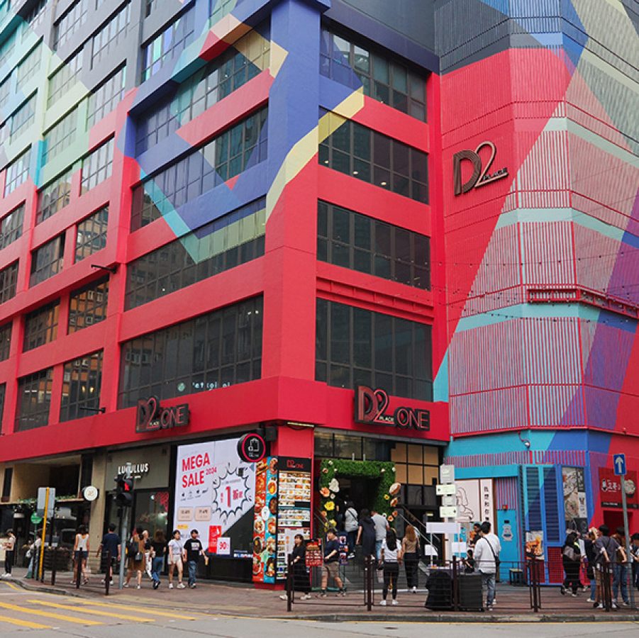 People walking in front of D2 Place, which has a patterned, brightly coloured façade. 