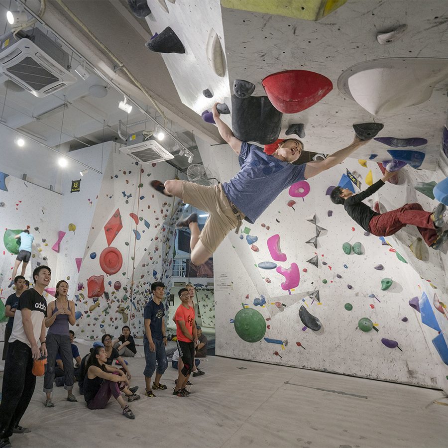 A group of sport climbers watching in anticipation as two climbers scale the wall at Banana Climbing in Shenzhen.