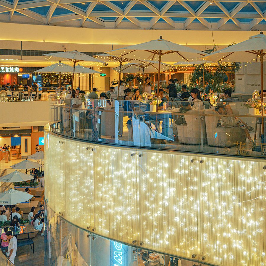 Top floors of MixC Wanxiang Tiandi where people dine under patio tables and romantic lights.