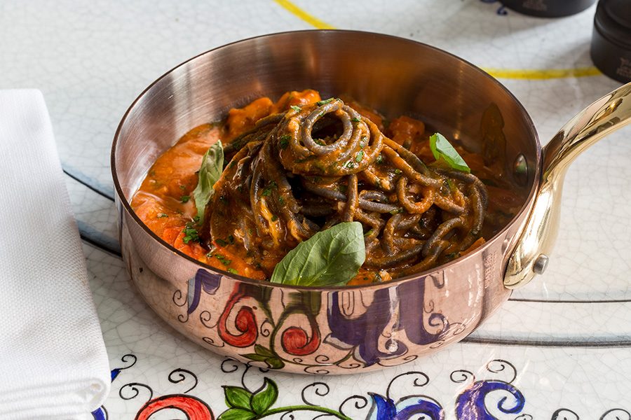 Black pasta dish in a copper pot served at Mamo Michelangelo.