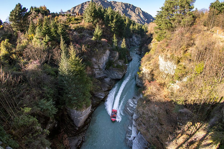 Boat cruising through a gorge in Queenstown