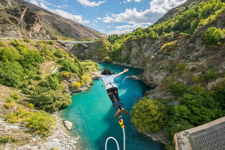 Woman bungee jumping over a river in Queenstown 