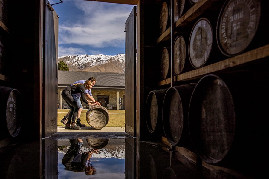 Man rolling a wine barrell in New Zealand 