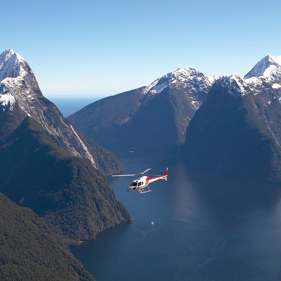 Helicopter flying over mountains and water in New Zealand 