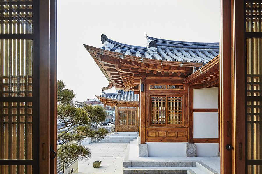 A side view of the traditionally designed exterior of Bukchon Binkwan by Rakkojae, seen through an open window