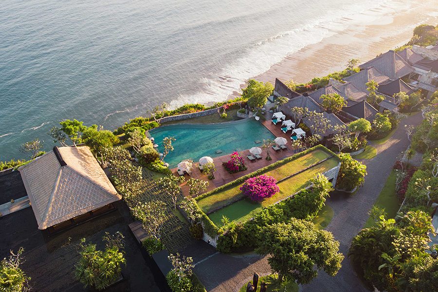 Bird’s eye ocean view of Bulgari Resort Bali on a sunny day, feautring the pool and beach 
