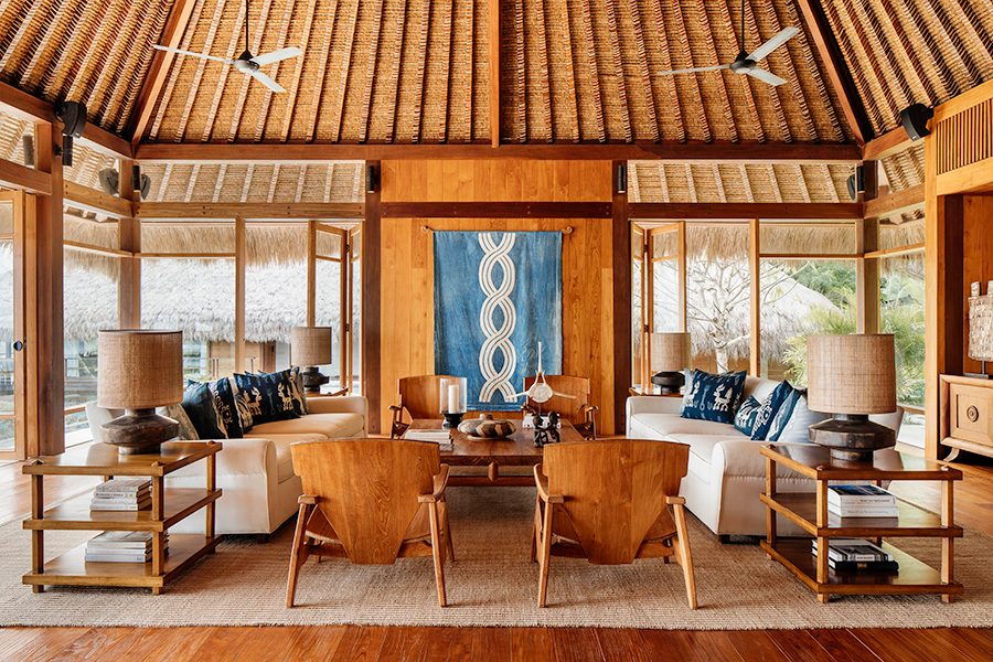 The lounge area inside NIHI Sumba resort, featuring floor-to-ceiling windows and traditional Indonesian design with nature in the background