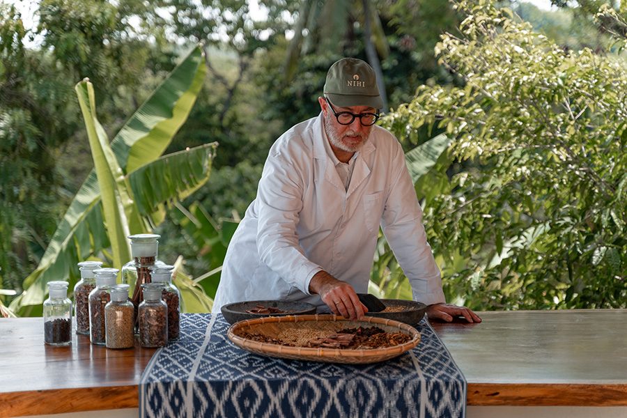 A man preparing spices on a traditional Indonesian rattan plate at a cooking workshop at Nihi Sumba, Indonesia 