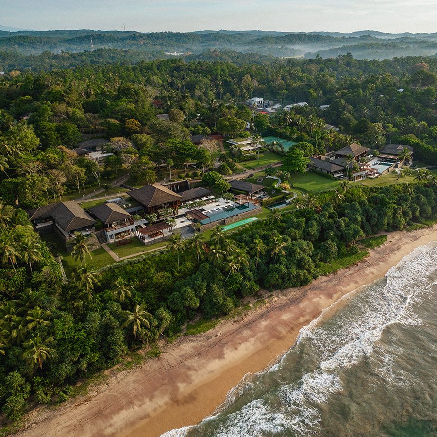 A drone shot of Ani Sri Lanka resort, surrounded by trees and bordering the beach 