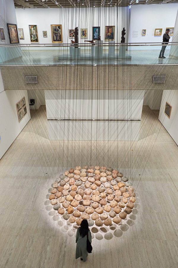 A woman views Ken Unsworth’s Suspended stone circle II (1974-77, 1988) at the Naala Nura building, Art Gallery of New South Wales