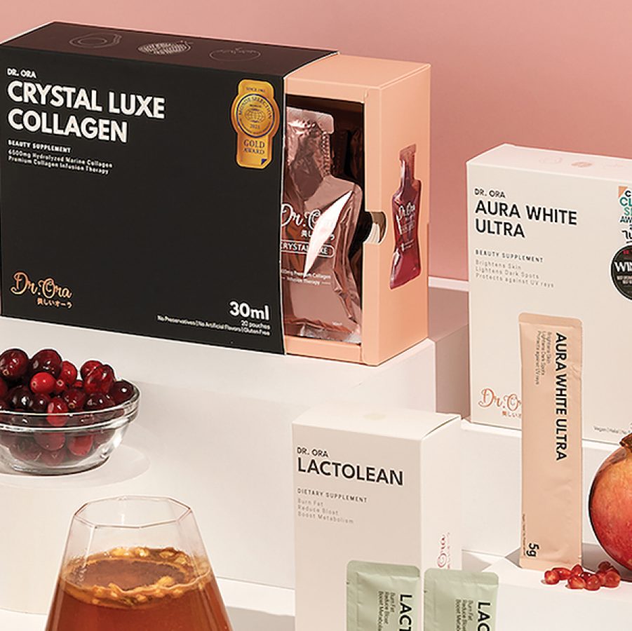 A collection of Singaporean beauty brand Dr. Ora’s beauty supplements such as Crystal Luxe Collagen and Aura White Ultra, displayed against a pink and white background.