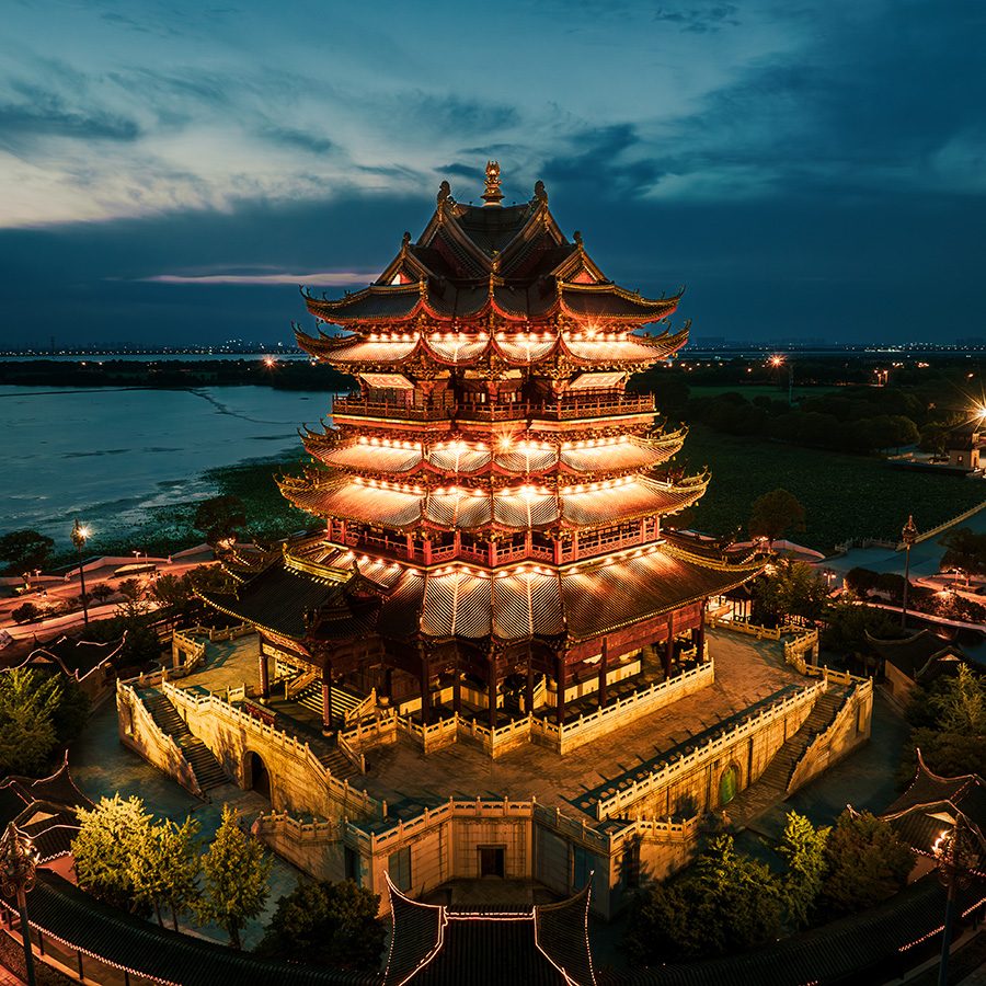 A temple on the water lit up at night in Suzhou. 