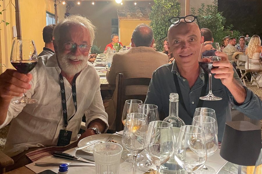 Two men raising their glasses at the dinner table. 