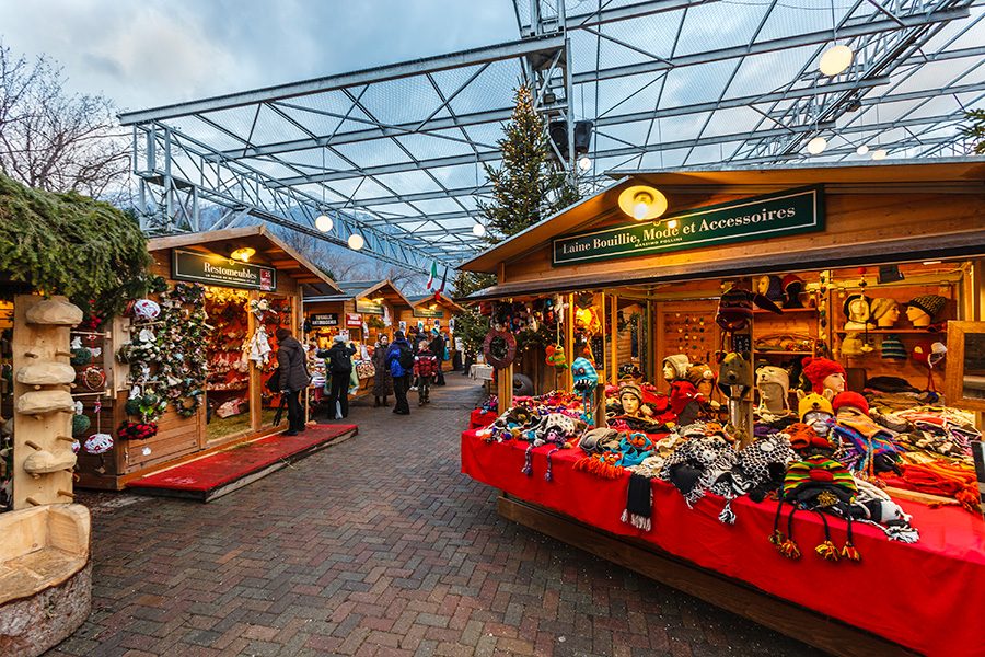 People peruse Christmas market stalls selling crafts in Aosta.